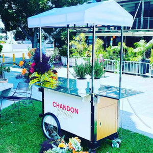 Premium coffee cart designed for mobile espresso and coffee service, featuring high-quality finishes, storage compartments, and built-in equipment space. Perfect for events, markets, and cafes on the go. Available at Promo Wheels.