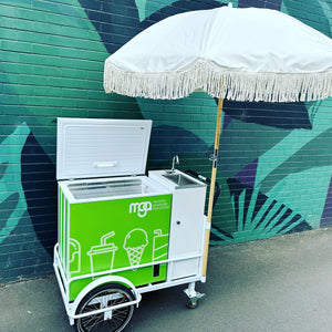 Fun ice cream cart featuring a green design and parasol, supplied by PromoWheels, ready to serve tasty treats at events and gatherings.